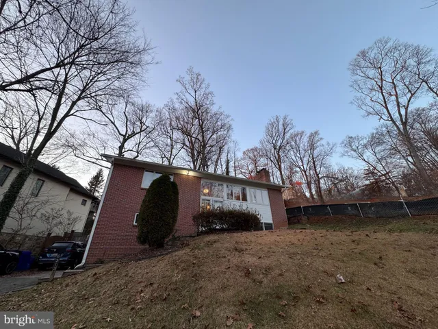 a view of a house with backyard and trees