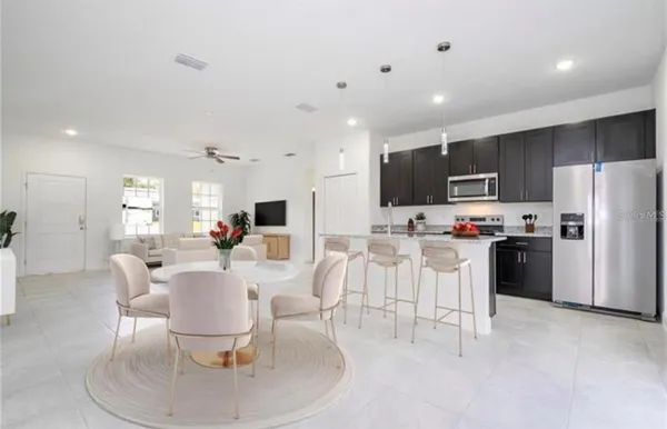 a living room with stainless steel appliances kitchen island furniture and a dining table with garden view