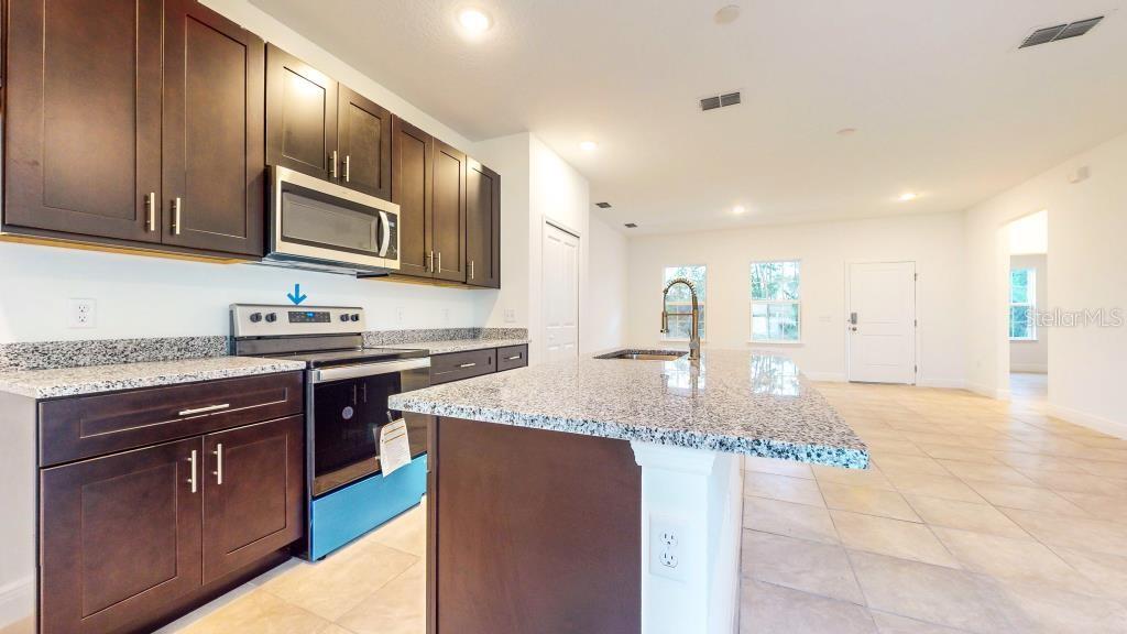 9809 North Swanee Terrace Dunnellon, FL 34433 - Photo 10 of 24 a kitchen with stainless steel appliances granite countertop a sink stove refrigerator and cabinets