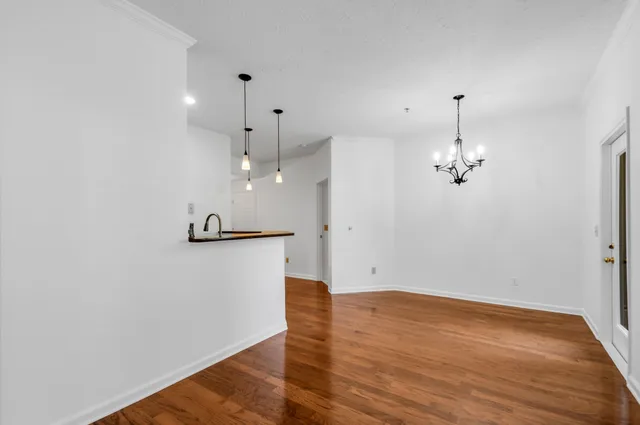 a view of a kitchen with a sink and dishwasher a refrigerator with wooden floor