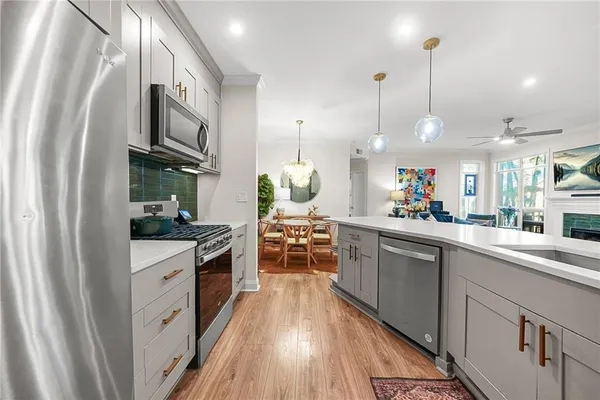 a kitchen with stainless steel appliances granite countertop a stove a sink and a refrigerator