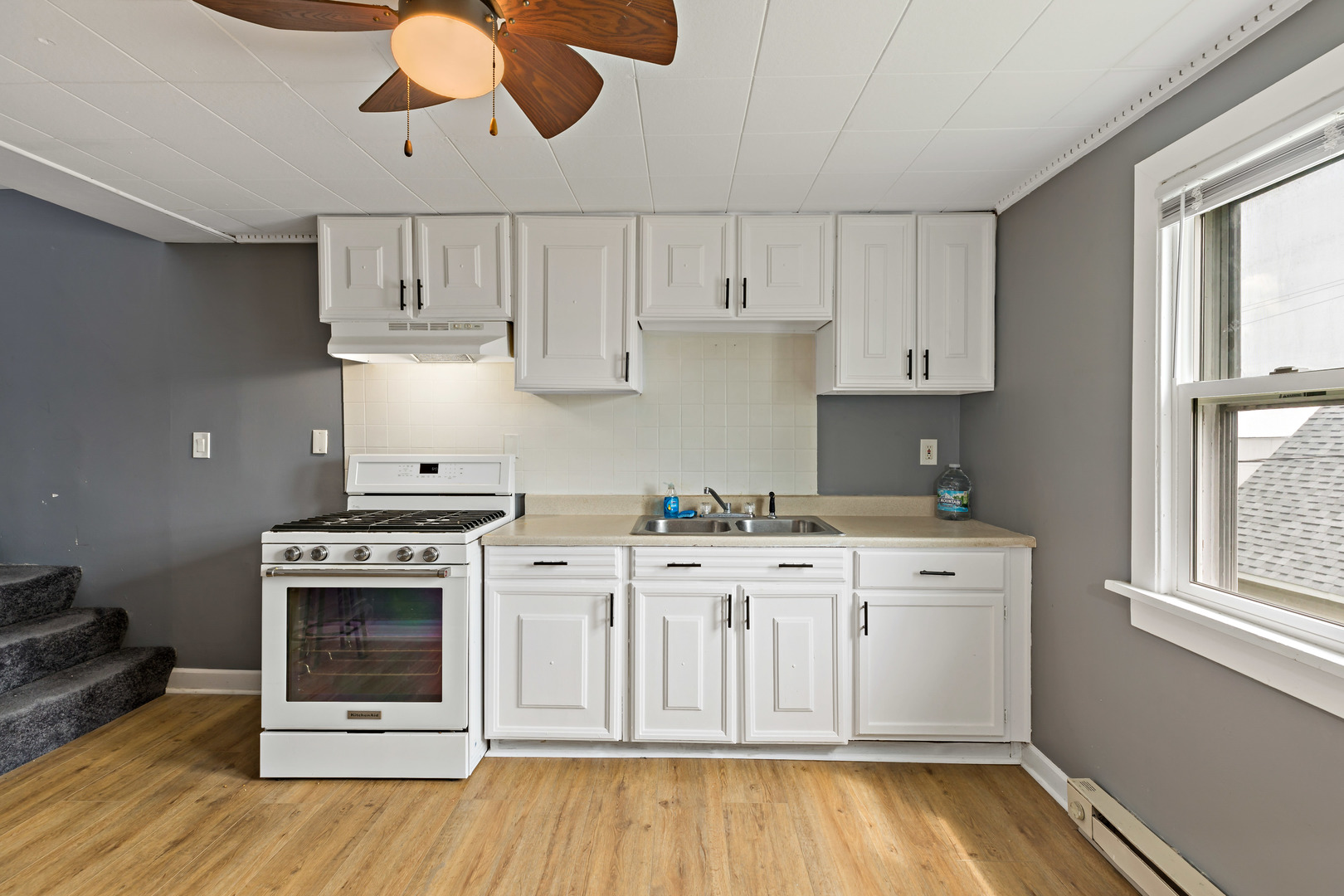 3441 Chicago Road Steger, IL 60475 - Photo 16 of 28 a kitchen with stainless steel appliances granite countertop a stove a sink and a white cabinets with wooden floor
