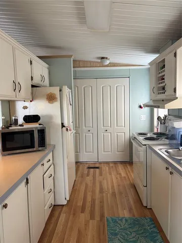 a kitchen with cabinets and wooden floor