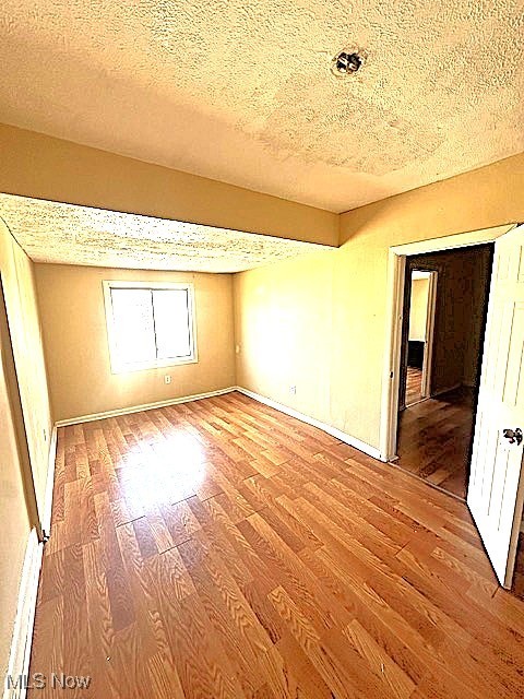 888 Rondel Road Cleveland, OH 44110 - Photo 12 of 35 Empty room with a textured ceiling and light wood-style floors
