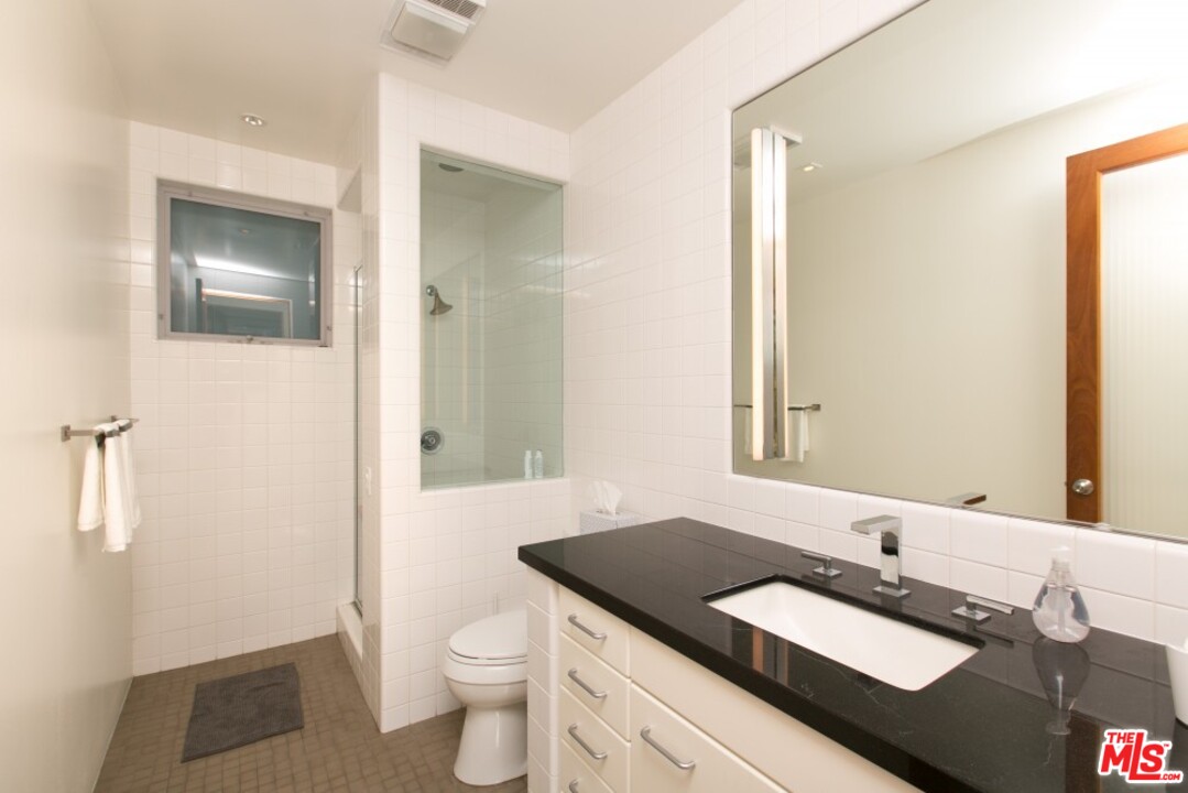 216 Grand Boulevard Venice, CA 90291 - Photo 17 of 28 a bathroom with a granite countertop sink a toilet and a mirror