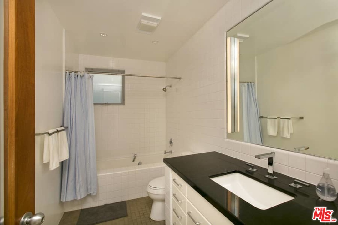 216 Grand Boulevard Venice, CA 90291 - Photo 19 of 28 a bathroom with a granite countertop sink toilet a mirror and shower