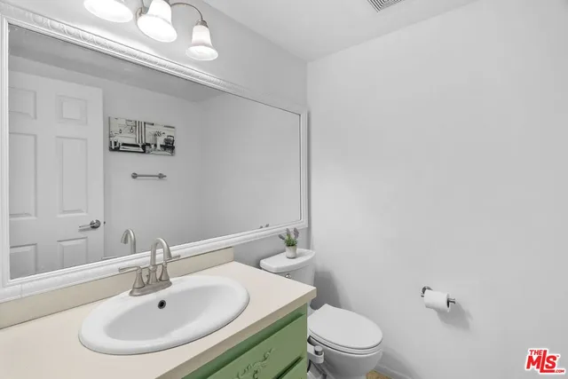 a bathroom with a sink a toilet and a mirror