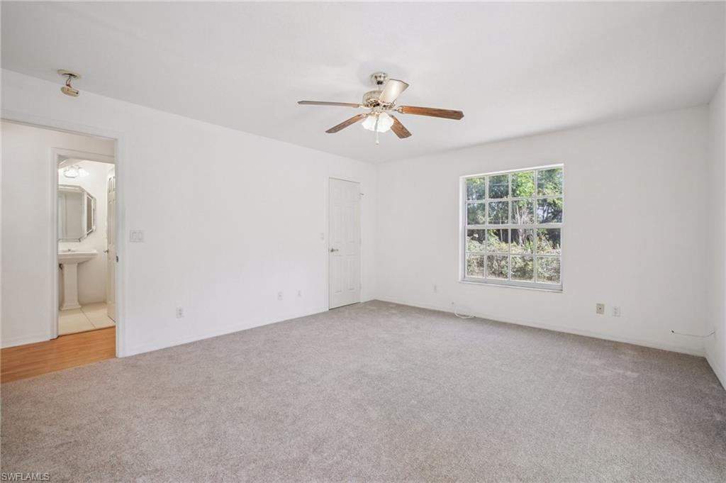 5348 Cypress Lane Naples, FL 34113 - Photo 14 of 28 an empty room with windows and fan