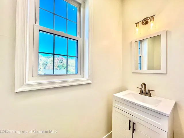 a bathroom with a sink a vanity and a window
