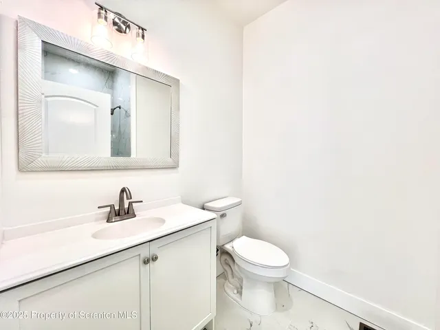 a bathroom with a toilet a sink and mirror