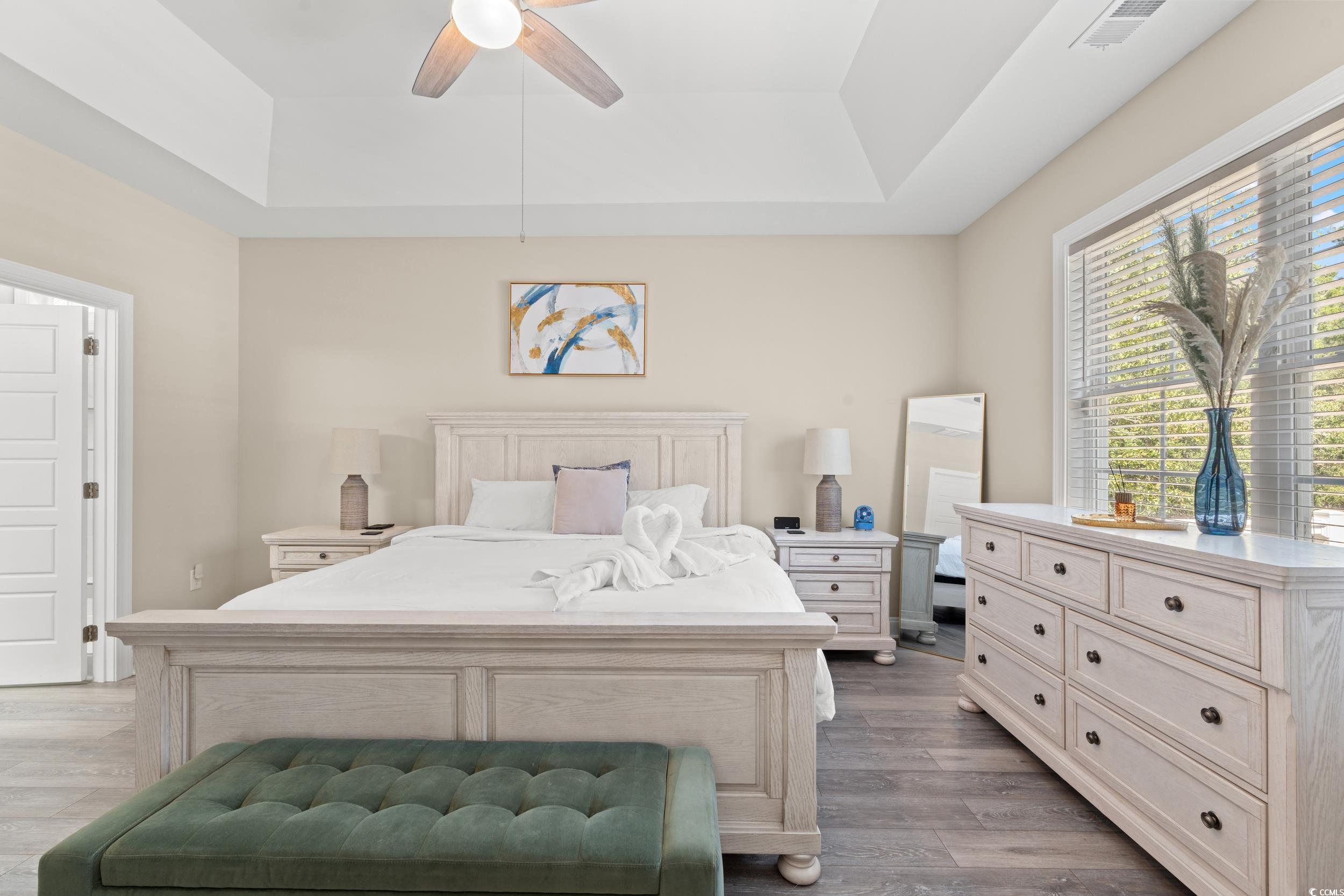714 Charlotte Road Myrtle Beach, SC 29577 - Photo 14 of 30 Bedroom with a tray ceiling, light wood finished floors, and a ceiling fan