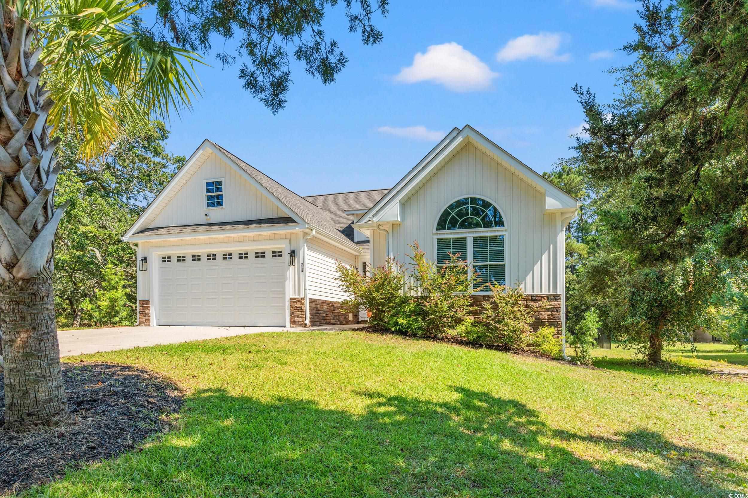 714 Charlotte Road Myrtle Beach, SC 29577 - Photo 2 of 30 View of front of property featuring a front yard, driveway, stone siding, and an attached garage