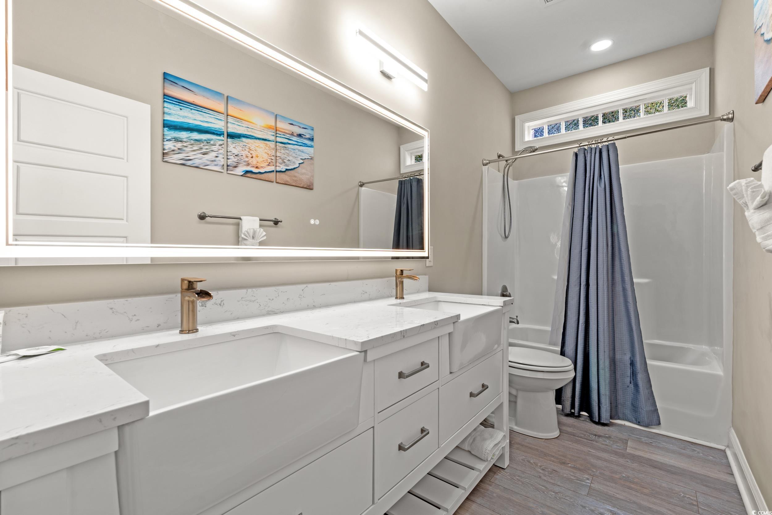 714 Charlotte Road Myrtle Beach, SC 29577 - Photo 21 of 30 Bathroom featuring shower / tub combo with curtain, double vanity, and light wood-style floors