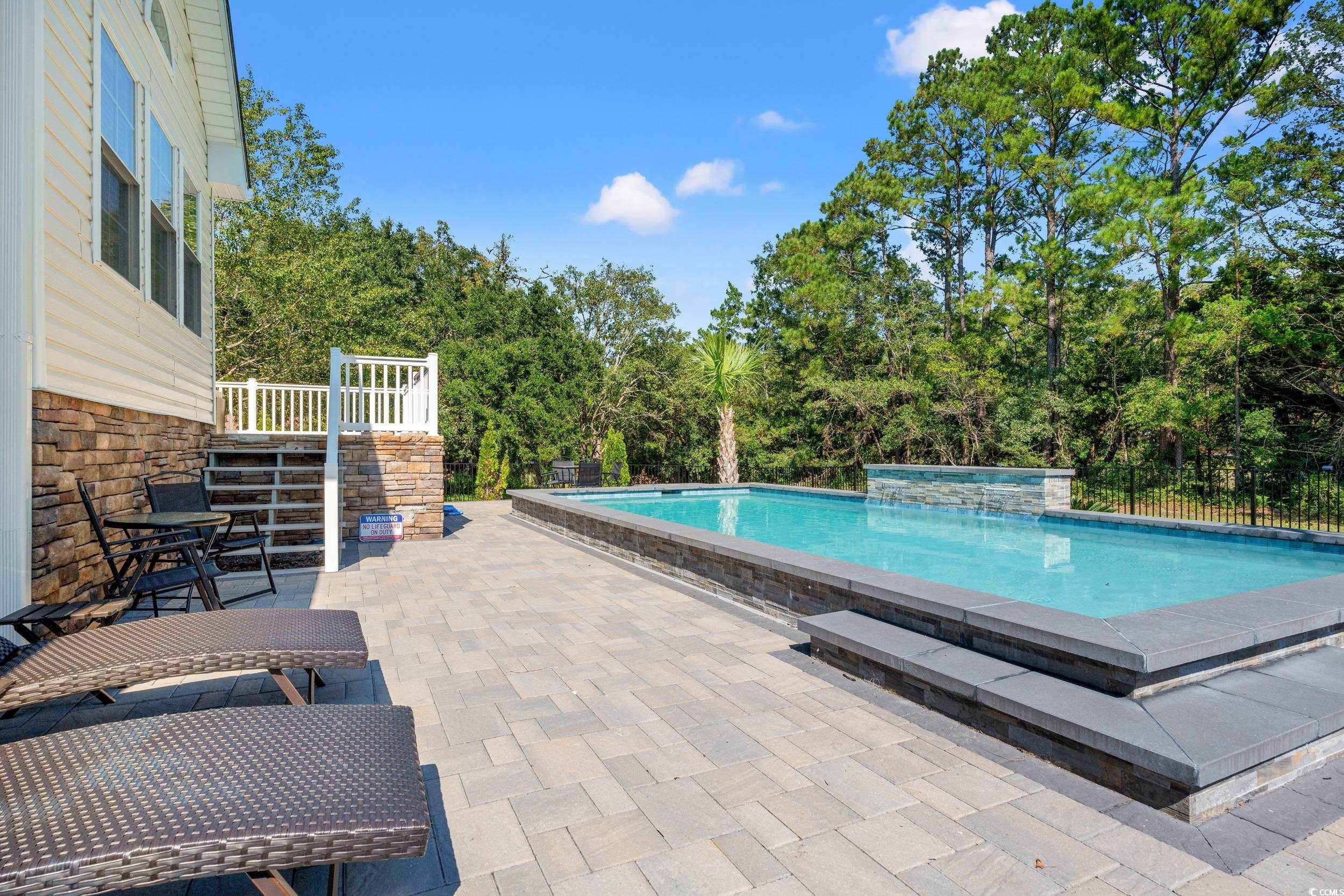 714 Charlotte Road Myrtle Beach, SC 29577 - Photo 5 of 30 Outdoor pool featuring a patio area and view of wooded area