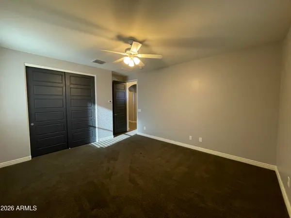 an empty room with a window and a fan