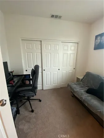 a view of a workspace with furniture and a window