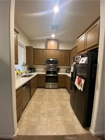 a kitchen with granite countertop a refrigerator and a stove top oven