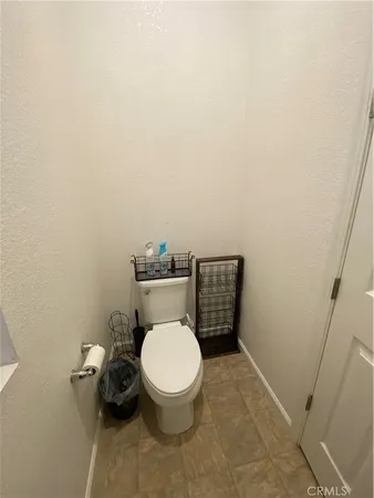 a white toilet sitting next to a wooden cabinet