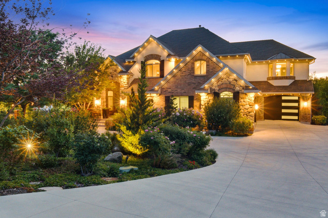 12308 Mariah Circle Draper, UT 84020 - Photo 286 of 293 Stately residence featuring a stone and brick facade, a multi-car driveway, mature landscaping, and an integrated garage with modern horizontal paneling