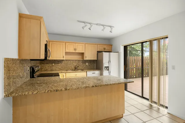 a kitchen with granite countertop a sink a refrigerator and a granite counter tops