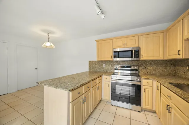 a kitchen with stainless steel appliances granite countertop a stove a sink and a microwave