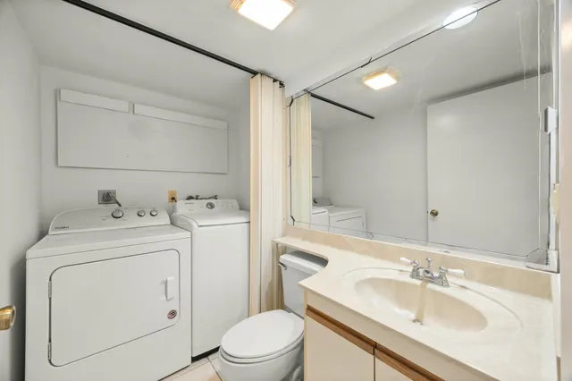 a view of bathroom with a sink and a washer dryer