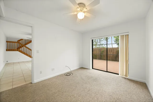 an empty room with fan and windows