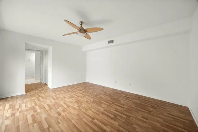 a view of empty room with wooden floor