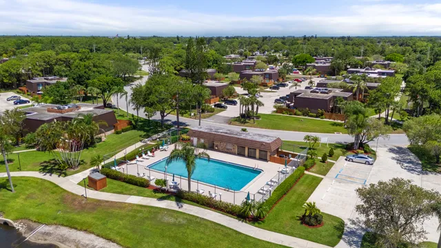 an aerial view of a tennis ground and a cars park side of the road
