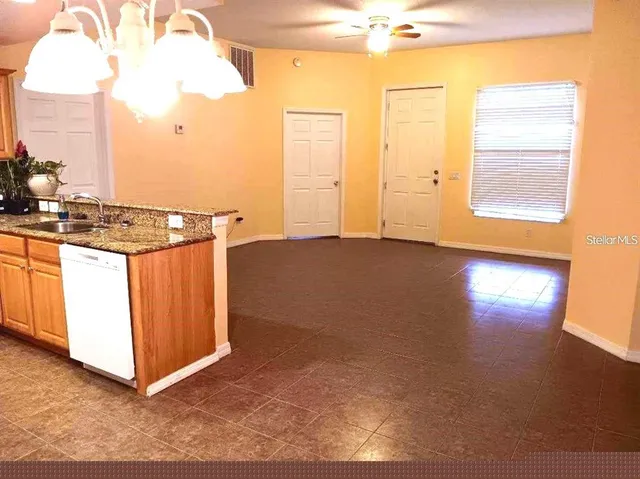 a view of a kitchen with wooden floor and a window
