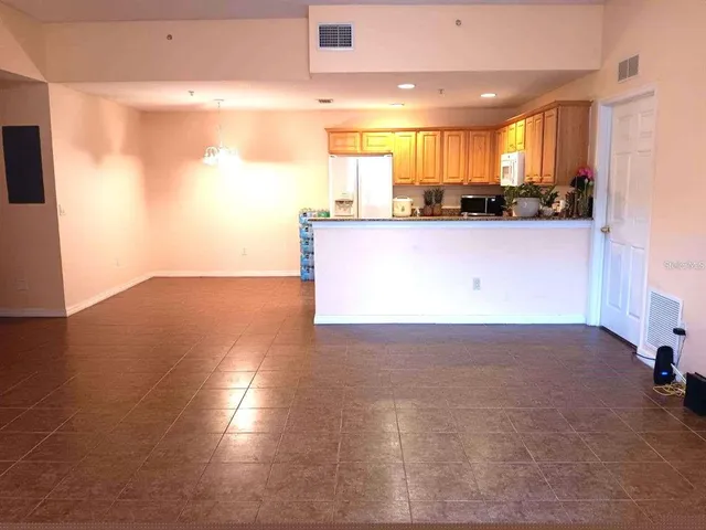 a view of a kitchen with kitchen island a sink wooden floor and a counter top space