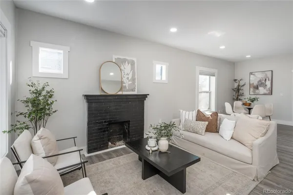 a living room with furniture a fireplace and a potted plant