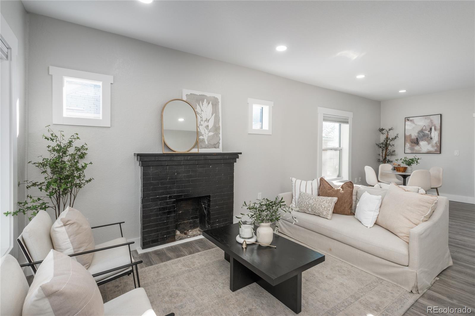 a living room with furniture a fireplace and a potted plant