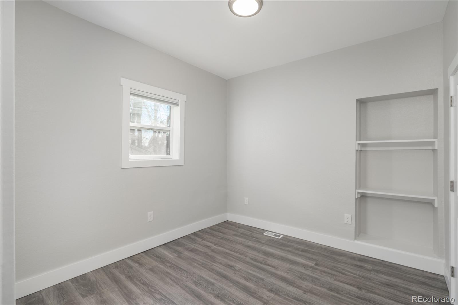2339 South Acoma Street Denver, CO 80223 - Photo 11 of 36 a view of an empty room with wooden floor and a window