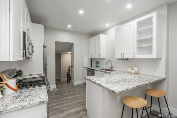 a kitchen with granite countertop kitchen island sink stove and refrigerator