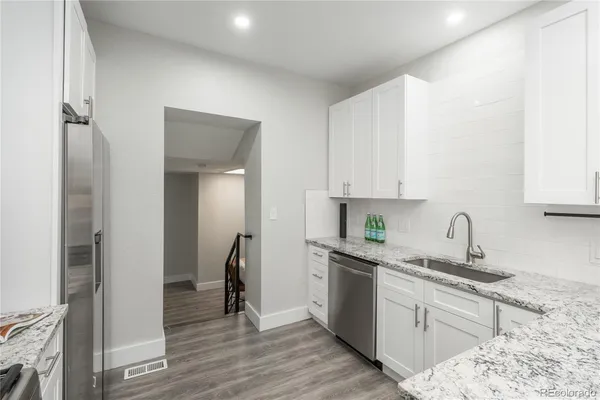 a kitchen with stainless steel appliances granite countertop a sink stove and refrigerator