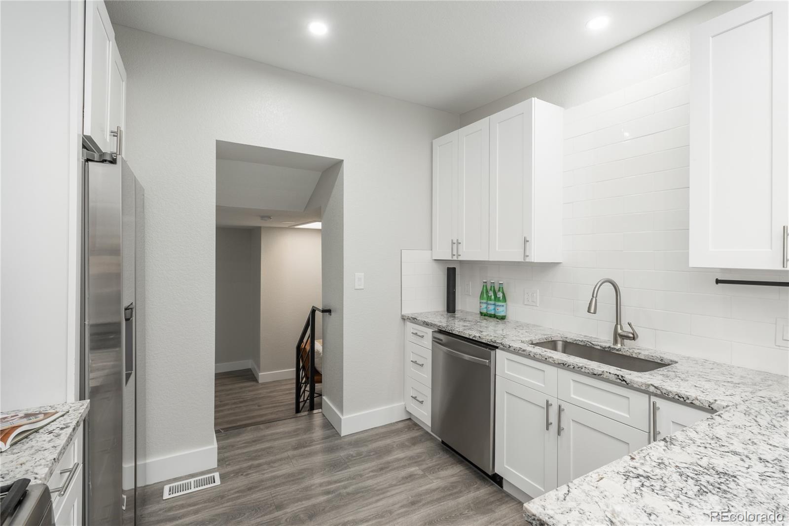 2339 South Acoma Street Denver, CO 80223 - Photo 14 of 36 a kitchen with stainless steel appliances granite countertop a sink stove and refrigerator