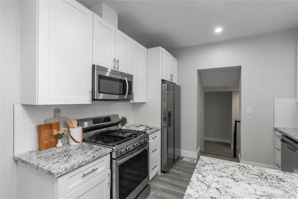 a kitchen with stainless steel appliances granite countertop a stove a sink and a refrigerator