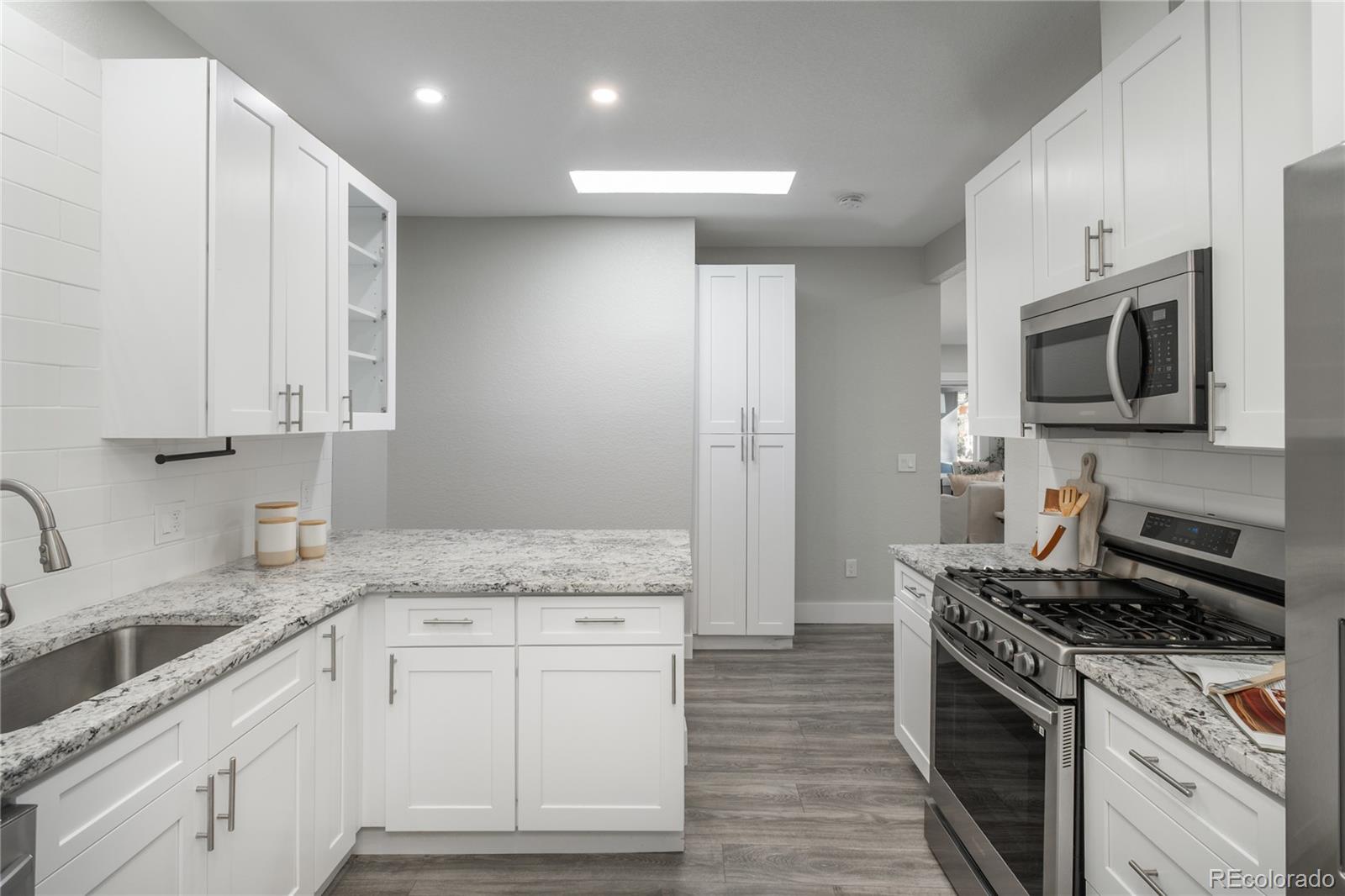 2339 South Acoma Street Denver, CO 80223 - Photo 16 of 36 a kitchen with granite countertop a sink stainless steel appliances and cabinets