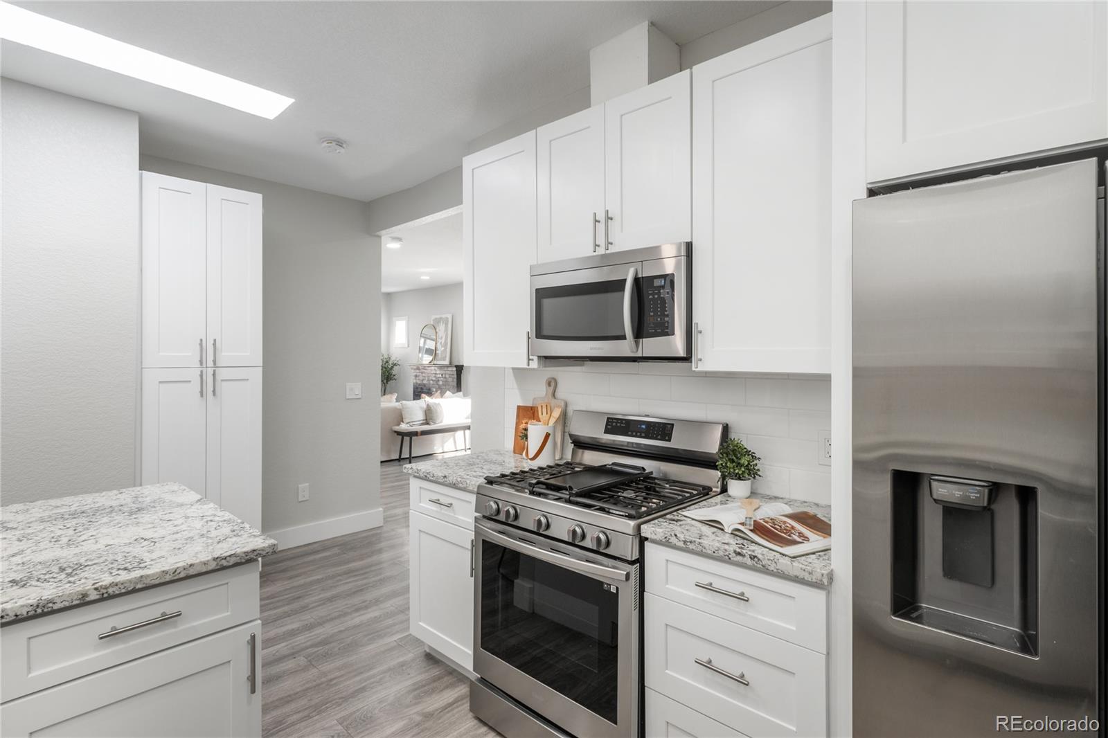 2339 South Acoma Street Denver, CO 80223 - Photo 18 of 36 a kitchen with granite countertop cabinets stainless steel appliances and wooden floor