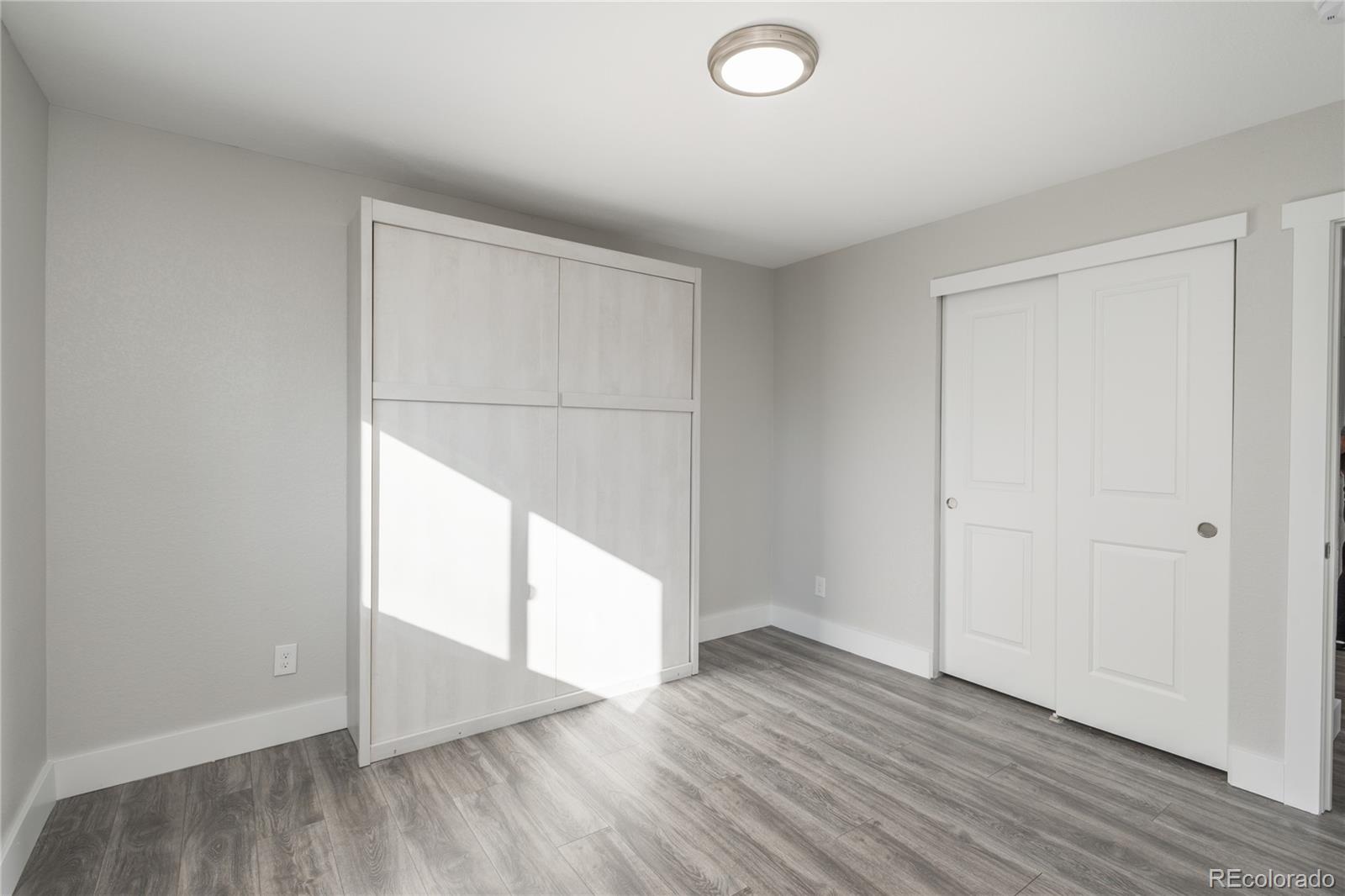 2339 South Acoma Street Denver, CO 80223 - Photo 25 of 36 an empty room with wooden floor and windows