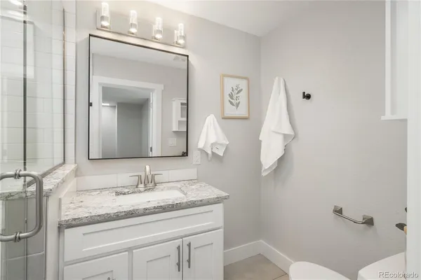 a bathroom with a granite countertop sink and a mirror