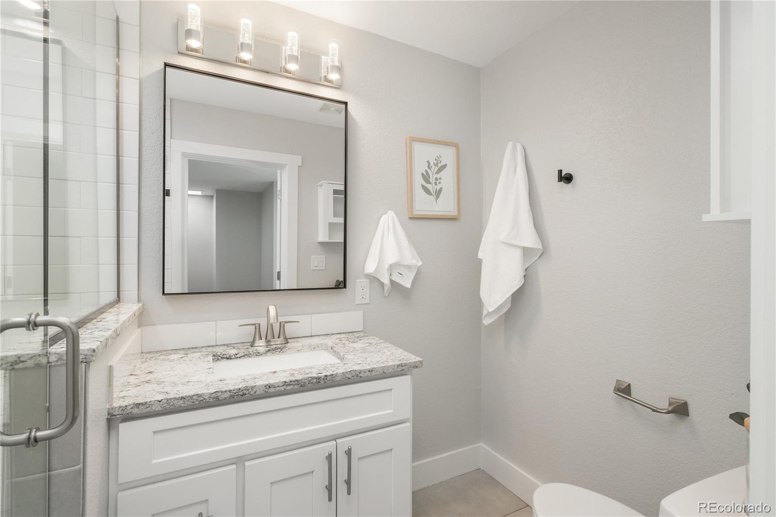 2339 South Acoma Street Denver, CO 80223 - Photo 27 of 36 a bathroom with a granite countertop sink and a mirror