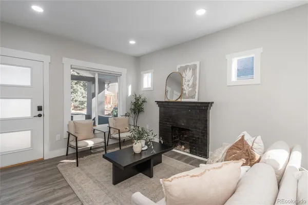 a living room with furniture a fireplace and a potted plant