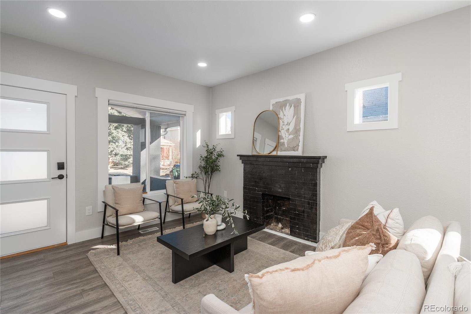 2339 South Acoma Street Denver, CO 80223 - Photo 4 of 36 a living room with furniture a fireplace and a potted plant