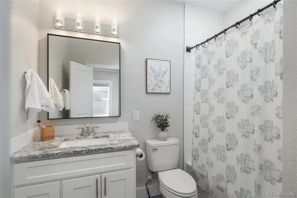 a bathroom with a granite countertop sink and a mirror