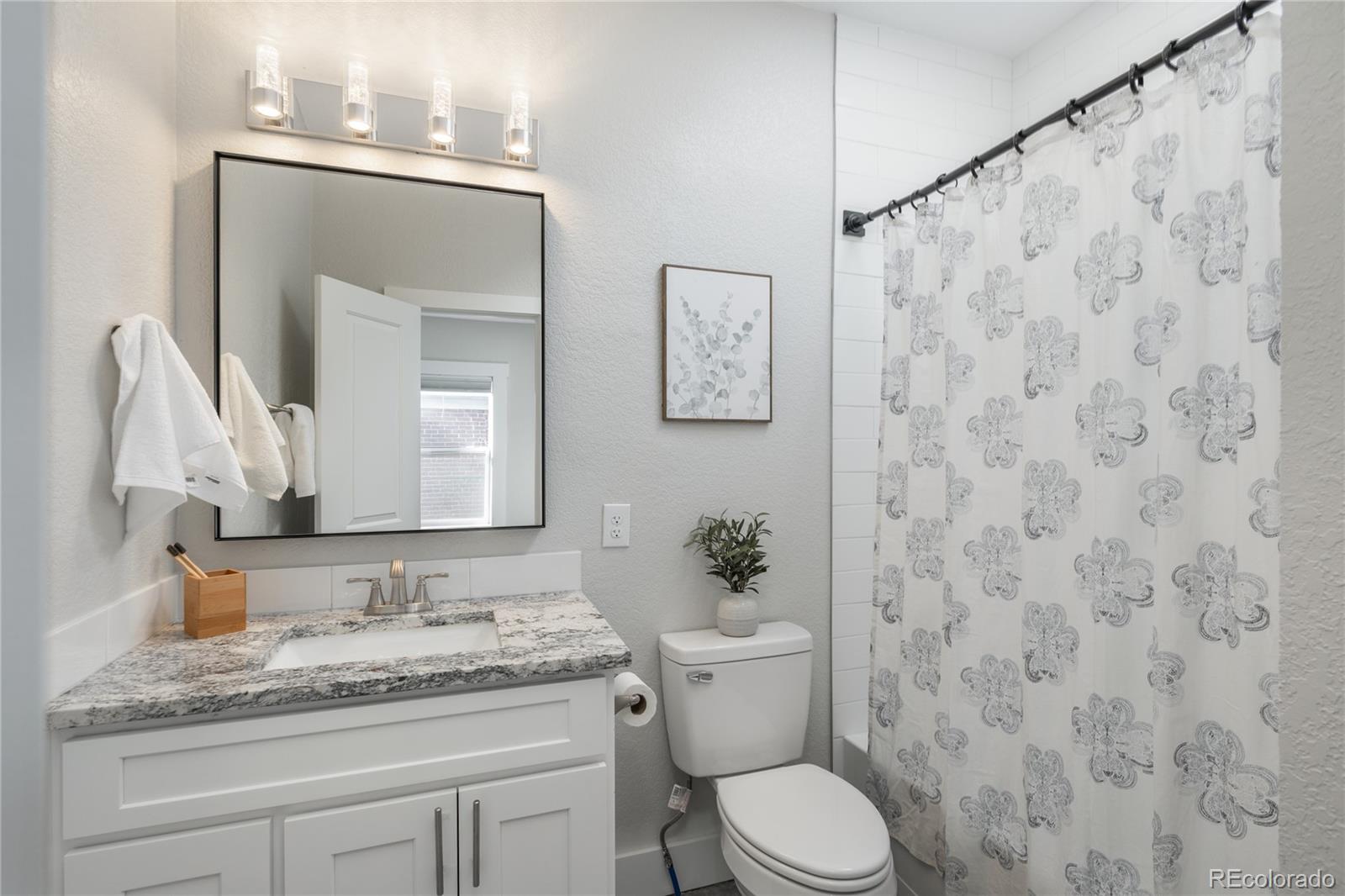 2339 South Acoma Street Denver, CO 80223 - Photo 10 of 36 a bathroom with a granite countertop sink and a mirror