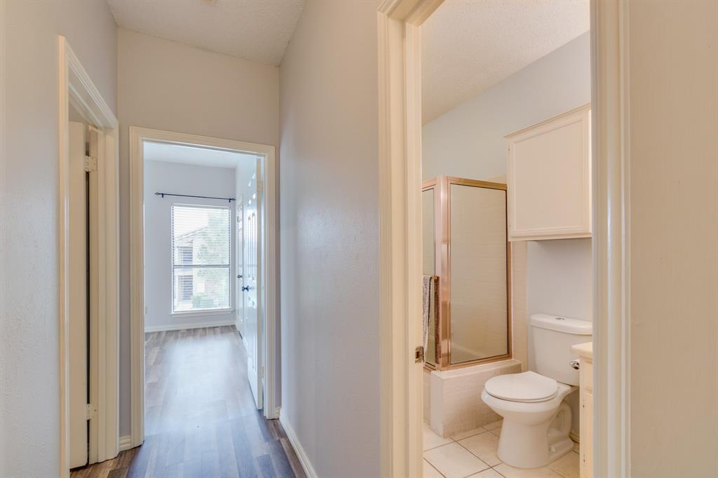 2100 Randy Snow Road, Unit 412 Arlington, TX 76011 - Photo 15 of 32 a bathroom with a granite countertop toilet a sink and a mirror