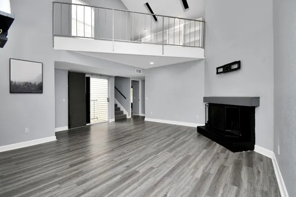 a view of a livingroom with wooden floor and a fireplace
