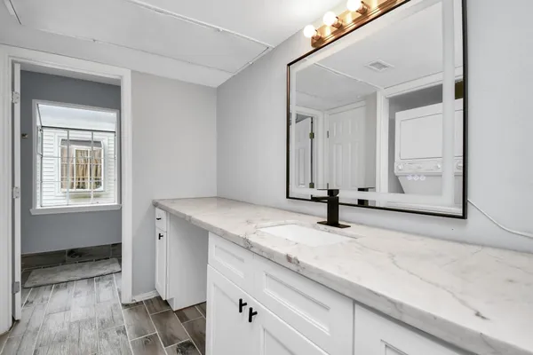 a view of a kitchen with sink and mirror